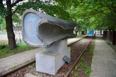 Yangpyeong İlçesi, Güney Kore - 19 Mayıs 2025: Oyma mavi çizgilerle yontulmuş taş heykel, doğayı, demiryolu mirasını ve modern sanat eserlerini birleştiren kullanılmayan raylar boyunca uzanır..