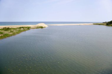 Ağzında, Wangpi Akıntısı yavaşça Doğu Denizi 'ne boşalır ve Kore' nin doğu kıyısı boyunca uzanan açık bir gökyüzünün altında kum ve sudan oluşan sakin bir sınır oluşturur..