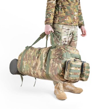 Askeri üniformalı bir asker beyaz arka planda kamuflaj çantası tutuyor. Silahlı kuvvetler kavramı.