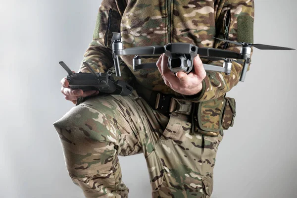 Modern army soldier with a remote control and drone prepares to fly. Crucial role of drones in smart war. Strategic surveillance, precision strikes, and intelligence gathering.