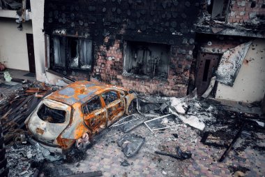 Irpin, Kyiv bölgesi, 2022. Evin bahçesinde parçalanmış bir araba. Rusya 'nın Ukrayna' ya karşı savaşı sırasında çıkan roket ateşinin sonuçları.