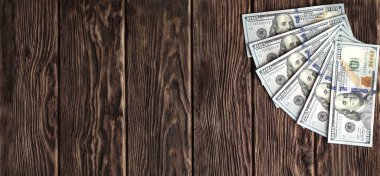 Kahverengi tahtaların ahşap zemininde yüz dolarlık banknotlar.