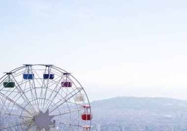 Mavi gökyüzünün arka planında çok renkli taksileri olan dönme dolap.