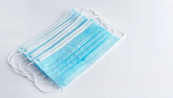 Set of surgical masks with rubber ear straps for protection against influenza and viruses on white background.