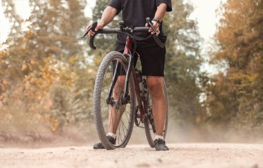 Tozlu bir kır yolunda çakıl bisikletli bir bisikletçi. Etkin yaşam tarzı kavramı.