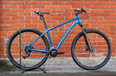 Duvara dayalı mavi bir dağ bisikleti. Sağlıklı bir yaşam tarzı. Bisiklet satışı.