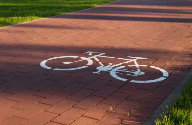 Şehir parkında kaldırımda bisiklet ikonu olan bisiklet yolu.