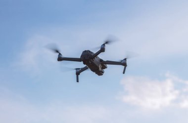 Gün batımında gökyüzünde insansız hava aracı ya da kuadkopter. Fotoğraf ve video çekimi için insansız araç.