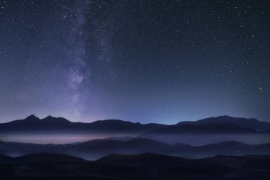 Yıldızlı gece gökyüzü Dağların üzerinde Samanyolu.