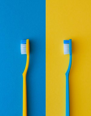 Sarı ve mavi arka planda diş fırçaları. Sağlık hizmeti konsepti. Yukarıdan görüntüle.