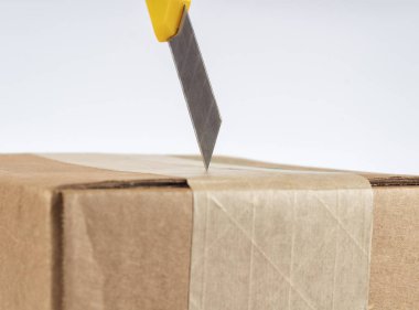 Sarı kırtasiye bıçağıyla karton kutuyu açıyorum. Kapat..