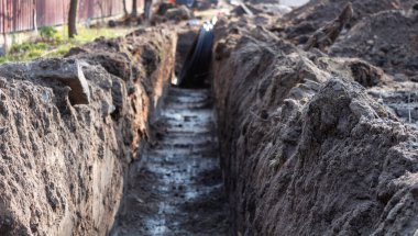 Toprak işi. Kablolar, borular döşemek için kazılmış uzun bir siper..