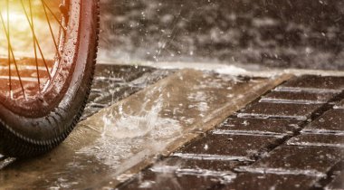 Yağmurda bisiklet tekerleği. Sprey ve yağmur damlaları. Bisikletçiler için yağmur mevsimi.