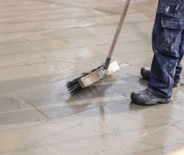 belediye işçisi süpürge sapı ile yol süpürme ve kepçe çöp toplar. sanitasyon işçi süpürme sokak