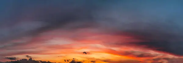 Dramatic sunset sky with clouds. Natural panorama of sky with setting sun.
