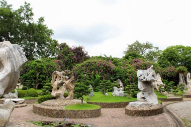 Dekoratif taş figürleri ve ağaçlardaki budanmış çalılarla güzel bir botanik bahçesi.