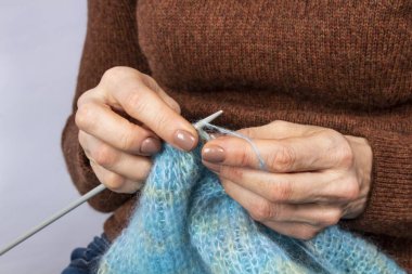 Örgü ören ellerin yakın çekimi. Örgü örme süreci. El yapımı..