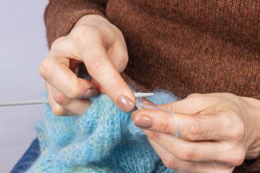 Örgü ören ellerin yakın çekimi. Örgü örme süreci. El yapımı..