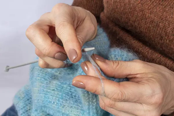 Örgü ören ellerin yakın çekimi. Örgü örme süreci. El yapımı..