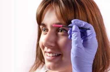 Güzel bir kadın güzellik salonunda kaş düzeltme prosedürü uygular..