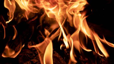 Ateşte bir kazanda yemek pişirmek. Karanlıkta ateş alevleri.