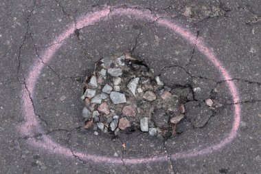 Yoldaki derin çukur. Yoldaki asfalt kaldırımın durumu kötü. Yol onarımı.