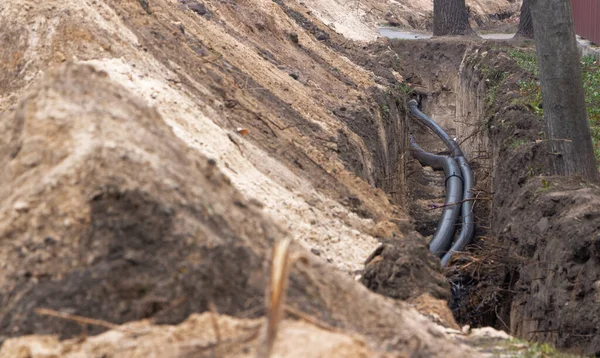 Yeraltındaki su kaynakları için siyah plastik borular. PVC borular. Kanalizasyon sistemi onarımı.