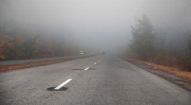 Sisli bir buluta doğru yol alıyoruz. Yoldayken, arabalar sisin içinden geçer. Yoldaki kötü görüntünün göstergesi.
