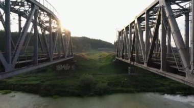 Nehrin karşısındaki demiryolu köprüsünden geçen banliyö elektrikli treni..