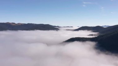 Havadan bakıldığında resimli bir dağ manzarası. Vadideki yoğun sislerin üzerinde uçan insansız uçak.