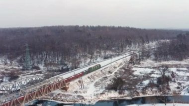 Tren kış ormanı boyunca demiryolunda ilerliyor. Hava görünümü.