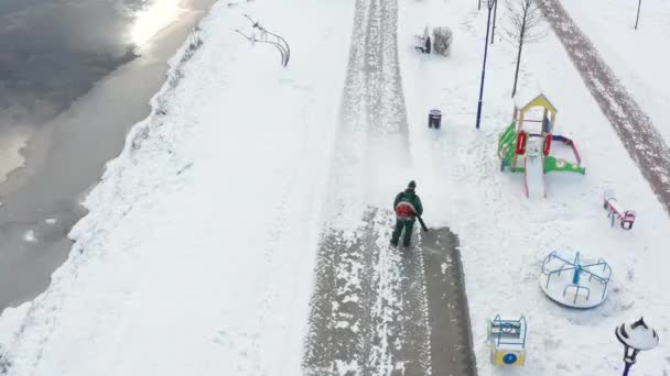 Werknemer Verwijdert Sneeuw Van Voetgangers Stoep Het Park Met Een — Stockvideo