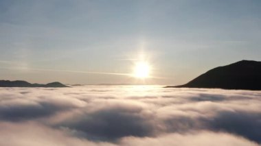 Bulutların üstünde, bulutların üzerinde, hava manzaralı güzel bir sabah güneşi doğuyor..