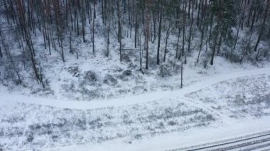 Boş demiryolu ile kaplı kış ormanının havadan görünüşü.