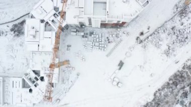 Crane, karla kaplı bir inşaat alanında. Havadan insansız hava aracı atışı..