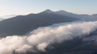 Gün doğumunda dağ vadisinde sis var. Sabah dağlarının hava manzarası. İHA görüntüsü.