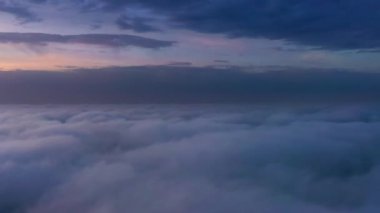 Bulutların üstünde dramatik gökyüzü olan gündoğumunun panoramik drone görüntüsü. Havadan bakınca inanılmaz bulutlu bir manzara.