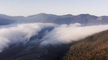İki büyük hareket eden bulutun güzel manzarası şafak vakti hava manzarasından dağ vadisini kaplıyor..