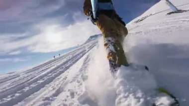 Bir snowboardcu dağlardaki gevşek karlara iniyor. Aktif yaşam tarzı kavramı.