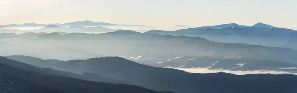 Gün doğumunda yumuşak ışıkla sisli dağ manzarası. Güzel doğa konsepti.