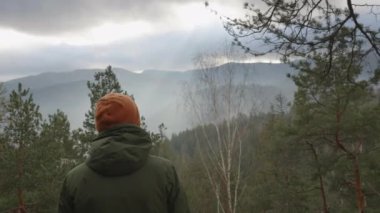 Genç aktif adam dağın tepesindeki güzel manzaranın tadını çıkarıyor. Seyahat ve turizm kavramı.