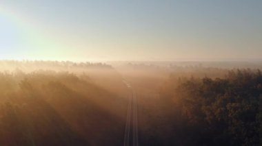 İnsansız hava aracı, gün doğumunda canlı ormanlarda sürünen bir treni yakalar. Güneş ışınları yolculuğunu aydınlatır. Şehir hayatı ve doğa arasındaki uyumlu ilişkiyi sembolize eder..