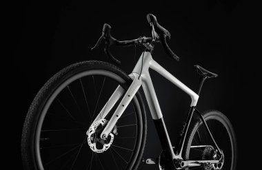 Siyah beyaz çakıl bisikleti, dinamik çekim ön tekerleğin altından siyah arka planda..