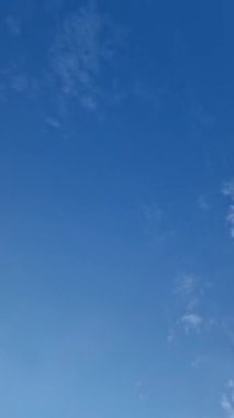 Mavi gökyüzü arkaplanı ve hareket eden birkaç küçük bulut. Hava bulutlu zaman çizelgesi