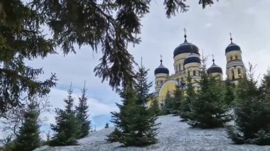 Hancu Monastery outdoors winter view. Traditional Christian Orthodox church located in the middle of the snowy woods in Republic of Moldova. Eastern Europe basilica traditional architecture style