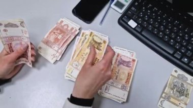 UNGHENI, MOLDOVA - 11 HAZİRAN 2024 Kadın eli para sayıyor ve masanın üzerindeki miktarları ayarlıyor. Moldova Cumhuriyeti farklı Lei banknotları