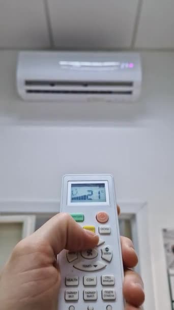 衣帽匠手拿着遥控器 按下空调系统的按钮 试图将房间的温度调整到一个舒适的水平 凉爽季节的家庭取暖 — 图库视频影像
