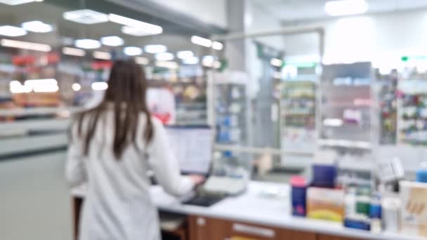 컴퓨터 판매자 카운터 레지스터에서 약사와 약국의 약국은 의약품 배경으로 선반을 — 비디오