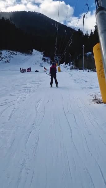 ブルガリアのバンスコススキーリゾートの雪の斜面を移動するドラッグリフトを使用してアクティブなスキーヤーのビュー — ストック動画