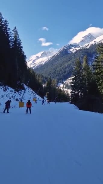 ブルガリアのバンスコスキーリゾートの冬季は スキーヤーがスロープやピリン山を背景に楽しむ様子を見ることができます — ストック動画